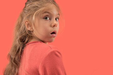 Image showing Cute little surprised girl in coral dress with long hair smiling to camera