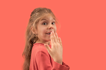 Image showing Cute little surprised girl in coral dress with long hair smiling to camera