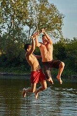 Image showing Guys jumping in a river