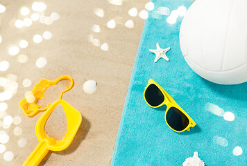 Image showing sunglasses, sand toys and ball on beach towel