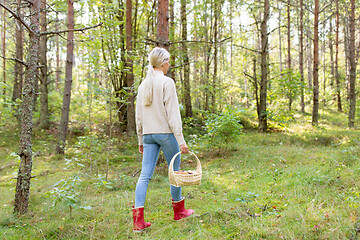 Image showing young woman picking mushrooms in autumn forest