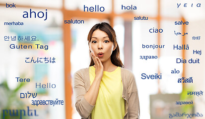 Image showing surprised asian woman over foreign words