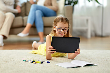 Image showing student girl with tablet pc lying on floor at home