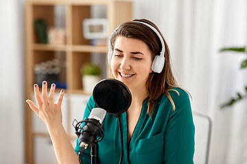 Image showing woman with microphone recording podcast at studio