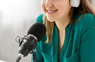 Image showing woman with microphone recording podcast at studio