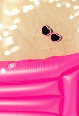 Image showing sunglasses and pink swimming mattress on beach