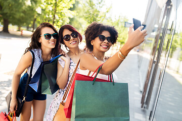 Image showing women with shopping bags taking selfie in city