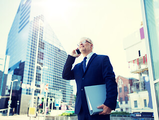 Image showing senior businessman calling on smartphone in city