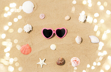 Image showing heart-shaped sunglasses and shells on beach sand