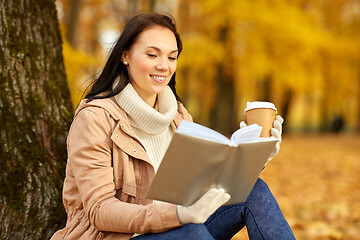 Image showing woman reading book with coffee in autumn park