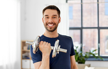 Image showing man exercising with dumbbell at home