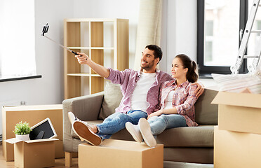 Image showing couple taking picture by selfie stick at new home