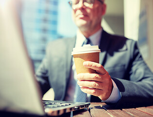 Image showing senior businessman with laptop and coffee outdoors