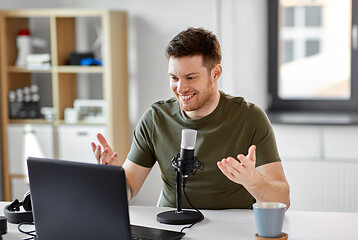 Image showing man with laptop and microphone at home office