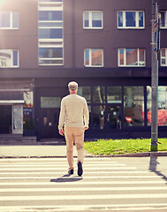 Image showing senior man walking along city crosswalk