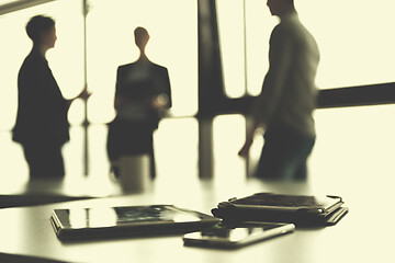 Image showing close up of tablet, business people on meeting in background