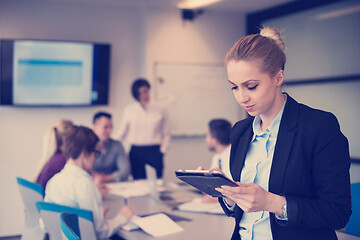 Image showing business woman working on tablet at meeting room