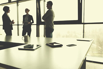 Image showing close up of tablet, business people on meeting in background