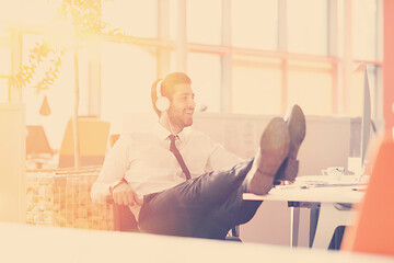 Image showing relaxed young businessman first at workplace at early morning