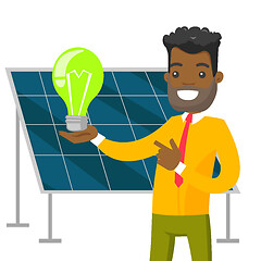 Image showing Engineer of solar power plant holding lightbulb.