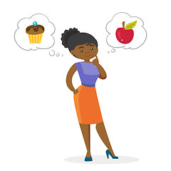 Image showing African woman choosing between apple and cupcake.