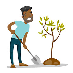 Image showing Young african-american gardener plants a tree.