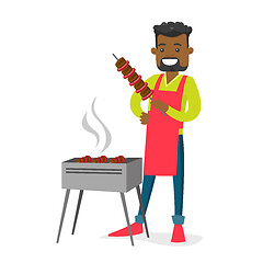 Image showing Young african-american man cooking shashlik.