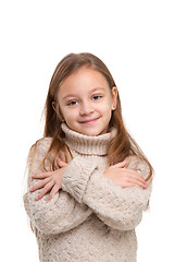 Image showing portrait of cute little kid in stylish knitted sweater looking at camera and smiling
