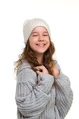 Image showing portrait of cute little kid in stylish knitted sweater looking at camera and smiling