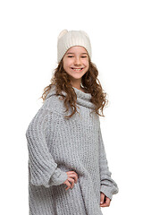 Image showing portrait of cute little kid in stylish knitted sweater looking at camera and smiling