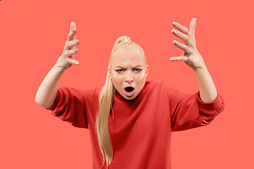 Image showing Portrait of an angry woman looking at camera isolated on a coral background