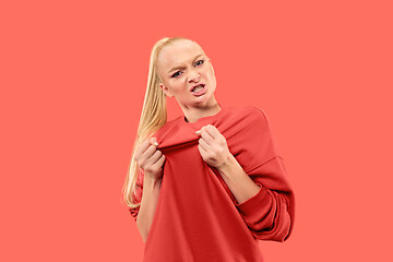 Image showing Portrait of an angry woman looking at camera isolated on a coral background