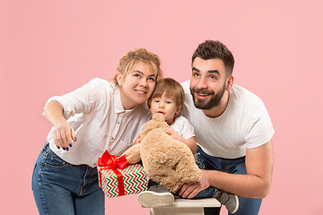 Image showing happy family with kid together and smiling at camera isolated on pink