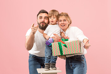 Image showing happy family with kid together and smiling at camera isolated on pink