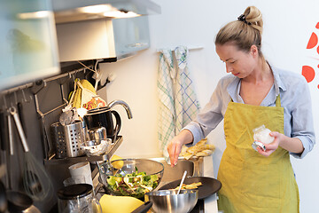 Image showing Stay at home and social distancing. Woman in her casual home clothing working remotly from kitchen dining table. Video chatting using social media with friend, family, business clients or partners