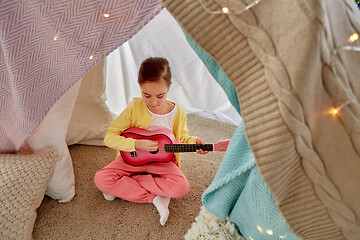 Image showing little girl playing guitar in kids tent at home