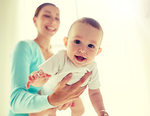 Image showing happy young mother with little baby at home