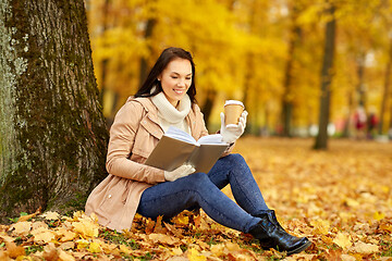 Image showing woman reading book with coffee in autumn park