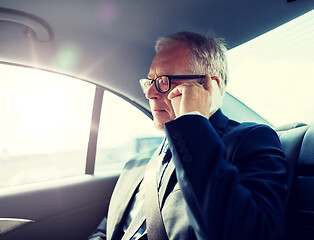 Image showing senior businessman calling on smartphone in car