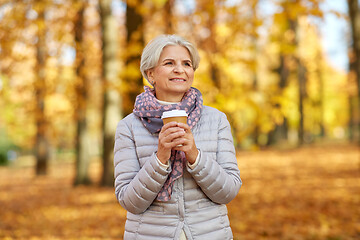 Image showing senior woman drinking coffee in autumn park