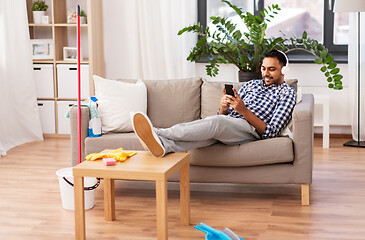 Image showing indian man in headphones after cleaning home