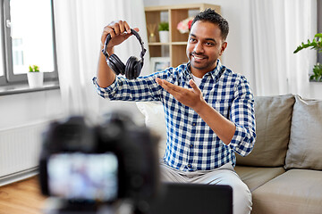 Image showing male blogger with headphones videoblogging at home