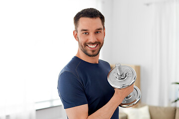 Image showing man exercising with dumbbell at home