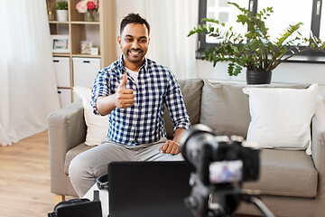 Image showing male blogger with camera videoblogging at home