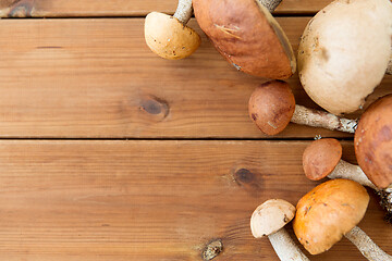 Image showing brown cap boletus mushrooms on wooden background