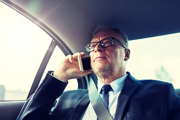 Image showing senior businessman calling on smartphone in car