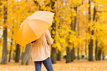 Image showing young woman with umbrella in autumn park