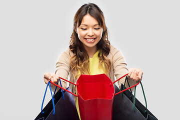 Image showing happy asian woman with open shopping bags