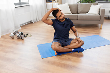 Image showing man training and stretching body at home