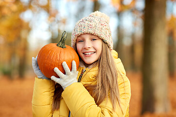 Image showing happy girl with pumpkin at autumn park